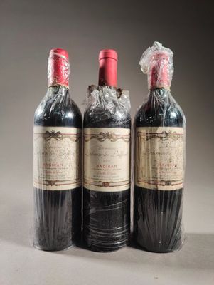 trois bouteilles de vin posées l'une à côté de l'autre sur une table