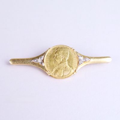 une image représentant une bague en or et diamants, avec une pièce de monnaie au centre