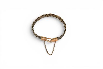 a close up of a bracelet on a white surface with a chain