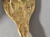 a gold fork with a picture of a woman on it