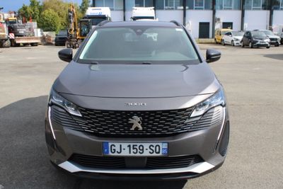 l'avant d'une voiture grise garée sur un parking à côté d'un immeuble