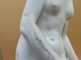 a white statue of a woman sitting on a table