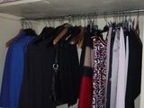a closet full of clothes and clothes hanging on a rack