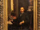 tableau représentant un homme en costume, assis à un bureau avec un livre
