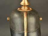 an antique helmet on a stand on a black background