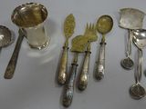 a lot of silver spoons and utensils on the table