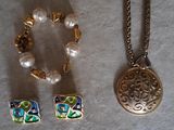 three pieces of jewelry that are on a table