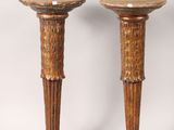 pair of carved wooden candlesticks on pedestals on a white background