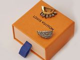 an orange box with a pair of earrings and a blue tie