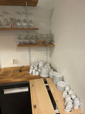 a small kitchen with a lot of dishes and cups on the counter