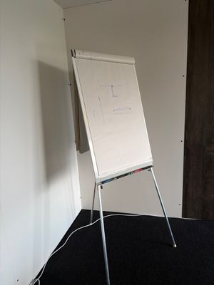 un tableau blanc posé sur un support dans un coin de la pièce