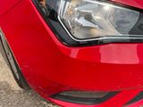 a close up of a red car ' s headlight and front bumper