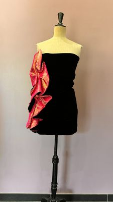 Le mannequin porte une robe rose et noire.