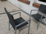 two chairs and a table outside on the patio