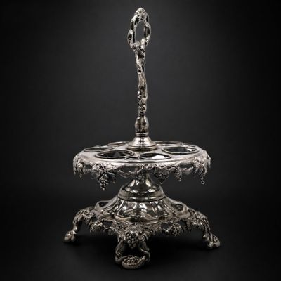 une assiette en argent sur laquelle repose une cuillère, sur fond noir