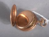 a small gold pocket watch with a chain around it