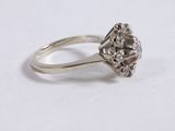 a close up of a diamond ring on a white surface