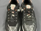 a pair of black and white sneakers with orange laces