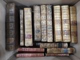 de nombreux livres anciens dans une boîte posée par terre