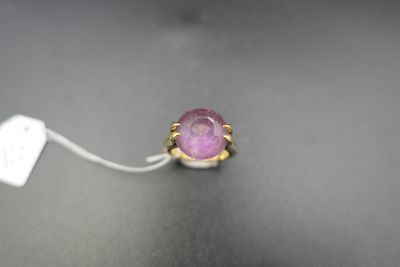 un gros plan d'une bague sertie d'une pierre rose