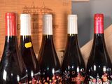 several bottles of wine are lined up in a row on a table