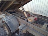 a truck that is sitting in the dirt under a building