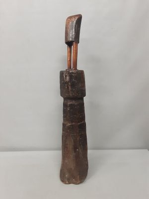 un gros plan d'une sculpture en bois posée sur une surface blanche