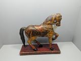 statue of a wooden horse on a stand on a white surface