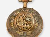 une montre de poche ancienne ornée d'un motif représentant un oiseau et une fleur