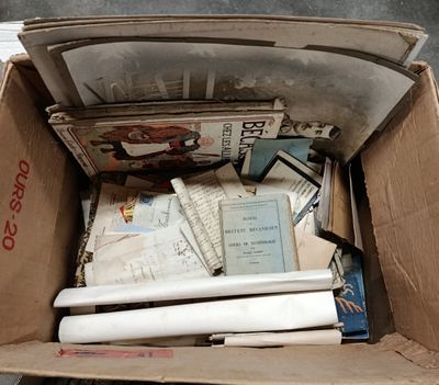 a cardboard box full of books and papers on the floor