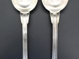 two spoons sitting next to each other on a table