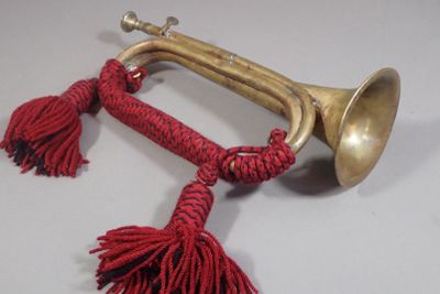 a brass trumpet with red tassels hanging from it