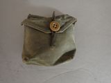 a small bag with a button on it sitting on a table