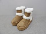 pair of brown boots with white fur lined up on a gray surface