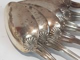a silver spoon and fork sitting on a white table