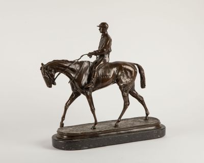 bronze statue of a jockey on a horse on a marble base