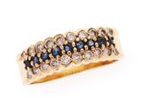 gros plan d'une bague en or avec des diamants bleus et blancs