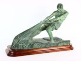 statue d'un homme tenant un poisson, posée sur un socle en bois