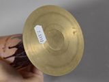 a person holding a gold plate with a sticker on it