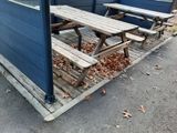 deux tables de pique-nique à côté d'un bâtiment bleu