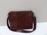 a brown leather purse sitting on top of a white table