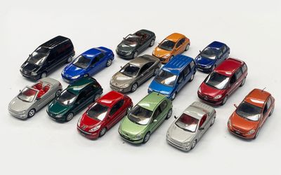 a lot of toy cars that are on a white surface