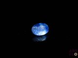 a close up of a blue stone on a black surface