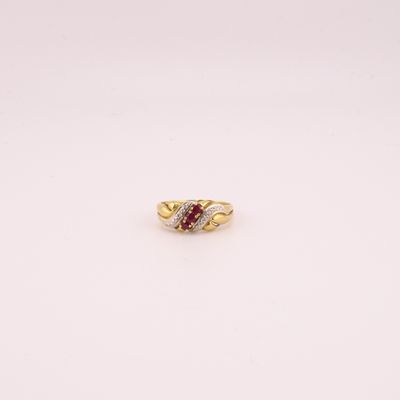 gros plan d'une bague en or avec une pierre rouge