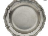 assiette en argent plaqué aux bords festonnés sur fond blanc