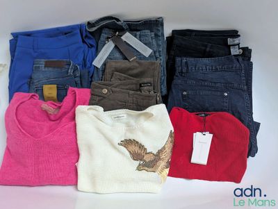 Plusieurs paires de jeans et de pulls sont disposés sur une surface blanche