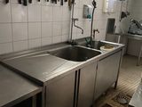 de nombreux couteaux accrochés au mur au-dessus de l'évier de la cuisine