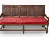 un banc en bois sur lequel est posé un coussin rouge