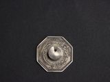 a close up of a metal object on a black surface