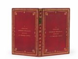 un vieux livre à la couverture rouge posé sur une surface blanche